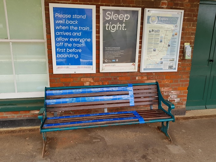 Bench cordoned off and social distancing advice poster at Halesworth station.