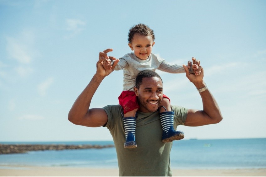 Man lifting up child on his arms at the beach