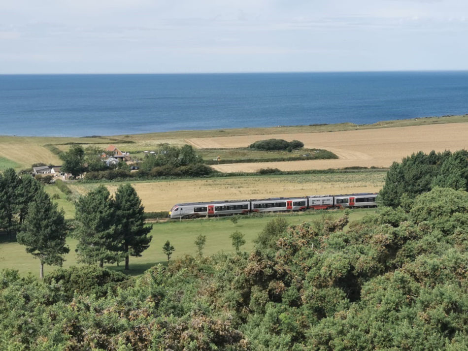 Greater anglia train with beach and sea in background