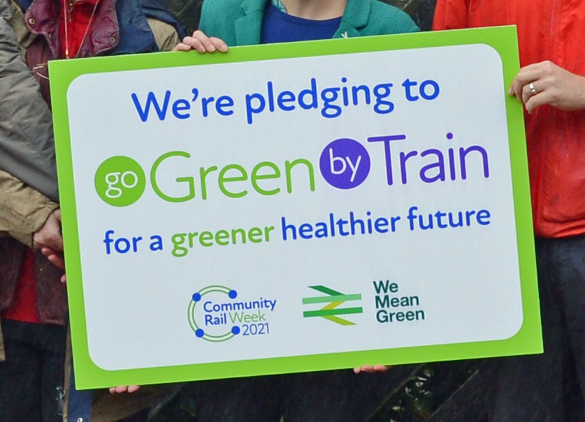 student and forum attendees with a large ‘Go Green by Train’ pledge card