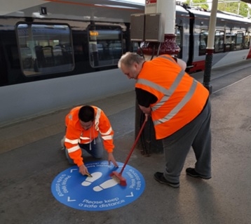 A floor vinyl being laid at Norwich rail station