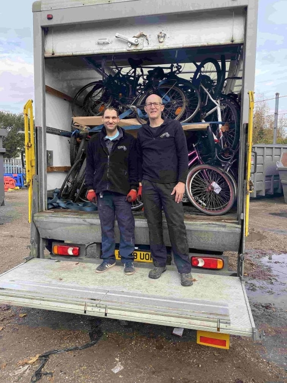 Representatives from Recycle standing in front of bicycles in a truck 