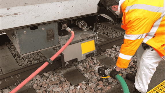 Eduard Szakacs from Greater Anglia train presentation removes vacuum hose after extracting waste