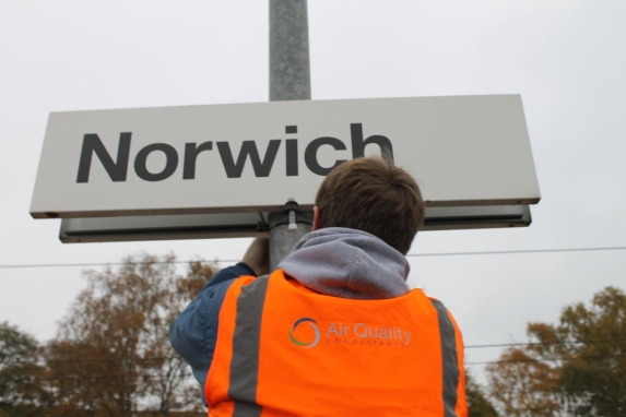 Worker fitting diffusion tube to Norwich station sign post