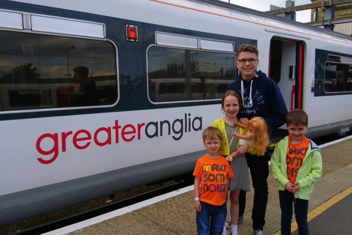Kids next to a Greater Anglia train