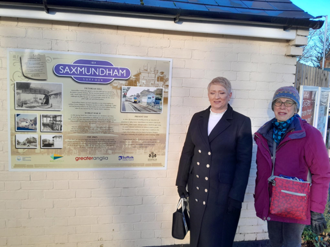 The new history board at Saxmundham rail station with station adopter volunteers, Sally Ford and Charlotte Hawkins