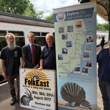People standing next to a folk east poster