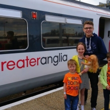 Kids next to a Greater Anglia train